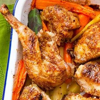 A top view of roasted rabbit meat with carrots and other vegetables