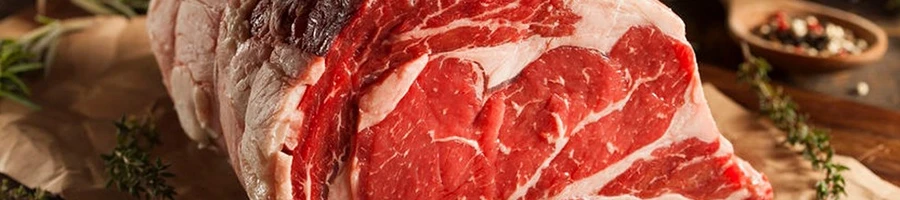 A close-up shot of raw prime rib being prepared and how much per person to serve