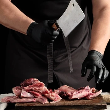 A butcher cutting raw rabbit meat
