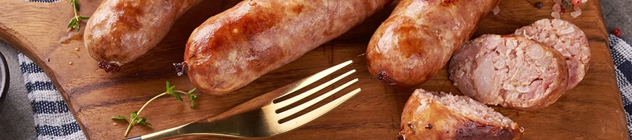 A close up shot of sausages on a wooden board that has gone bad