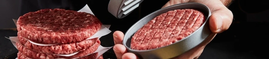 A person using a hamburger press in shaping his hamburger patties