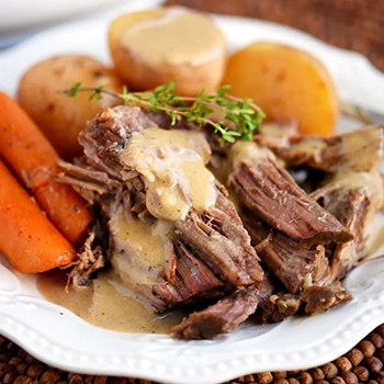 A serving of pot roast on a white plate