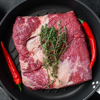 A top view of a raw brisket on a pan