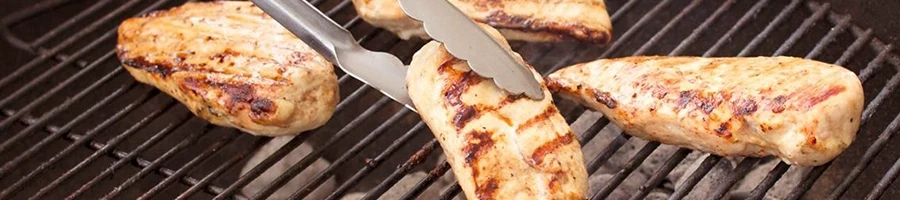 Cooking chicken breasts on a charcoal grill