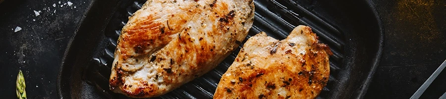 A top view of grilled chicken breasts on a grill pan