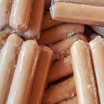 A top view of raw frozen hotdogs in the fridge