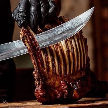 A butcher slicing lamb ribs