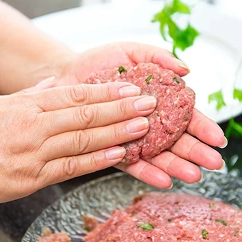 A woman making the right shape of a burger