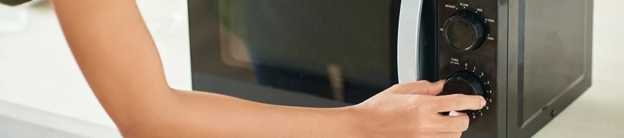 A woman using a microwave to thaw turkey