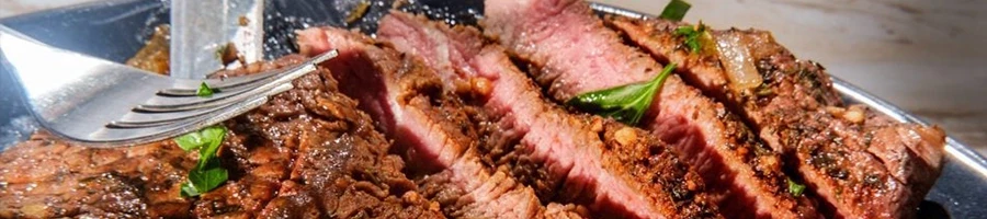 A close up shot of a sliced sirloin tip side steak on a plate