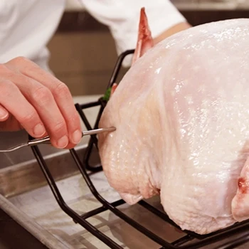 A chef checks the temperature to see if a turkey is thawed