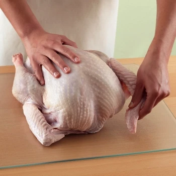 A person checks the turkey to see if it is thawed by touching it