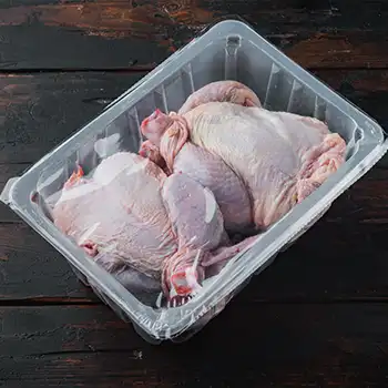 raw chickens inside a transparent container covered with plastic wrap