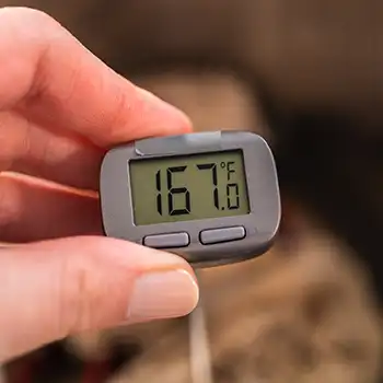 a person holding a cooking thermometer