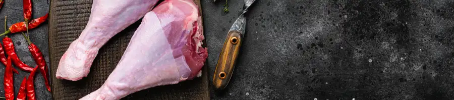 two turkey drumsticks on chopping board