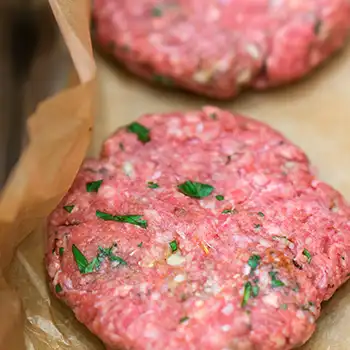 image of two raw burger patties in a pan