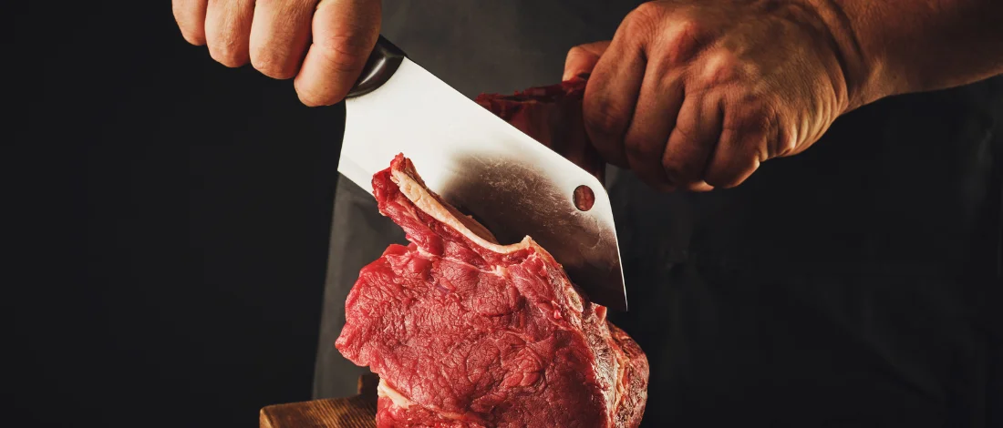 Man cutting bone off meat