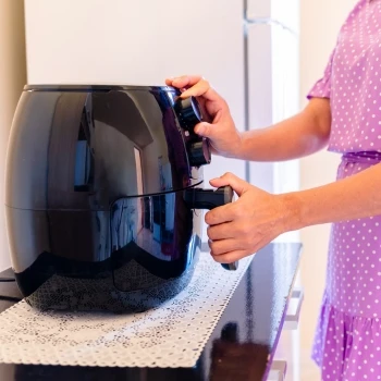 A woman preheating an air fryer