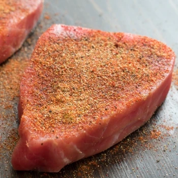 A raw steak full of spices