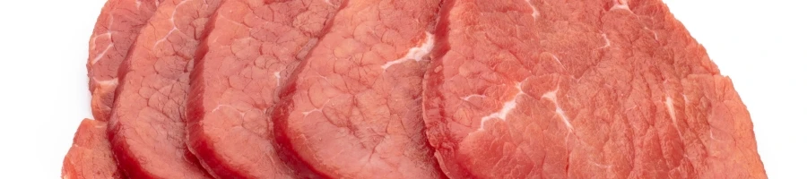 A top view of raw thin eye of round steak for the recipe