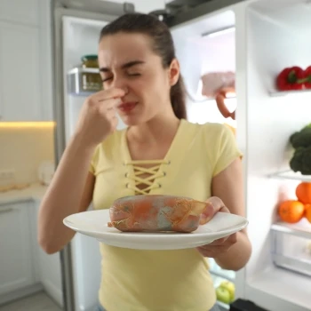 A woman holding a smelly spoiled meat