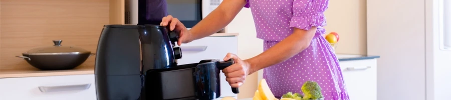 A woman using an air fryer to cook tri-tip steak