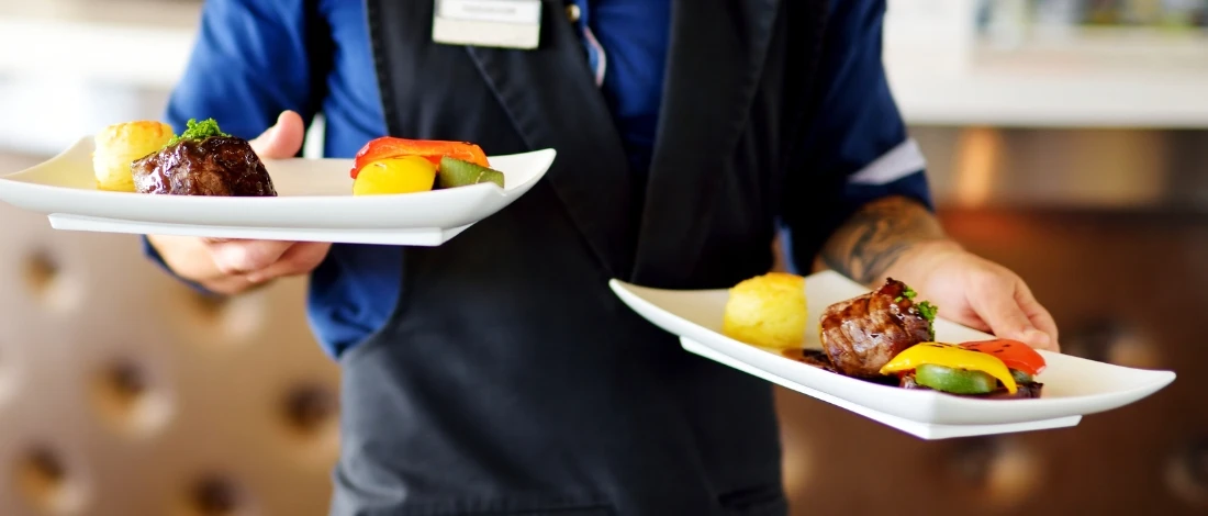 The waiter is serving a meat dishes