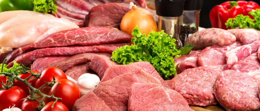 A tons of sliced red meat with few vegetables on the side