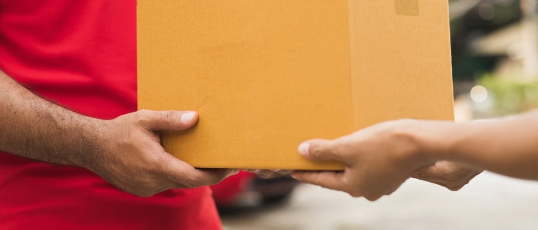 A person giving a box of food to the other person