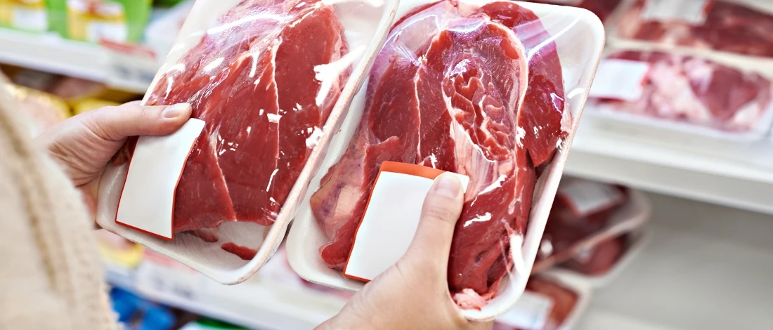A person holding two meats