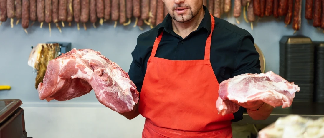A person holding two meats