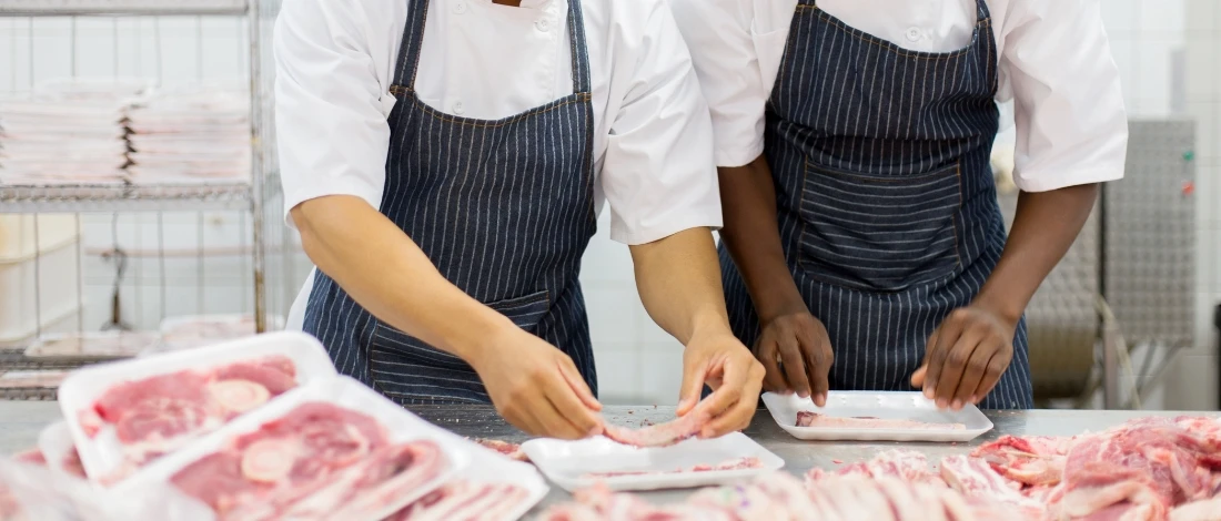 The two people are packing meats