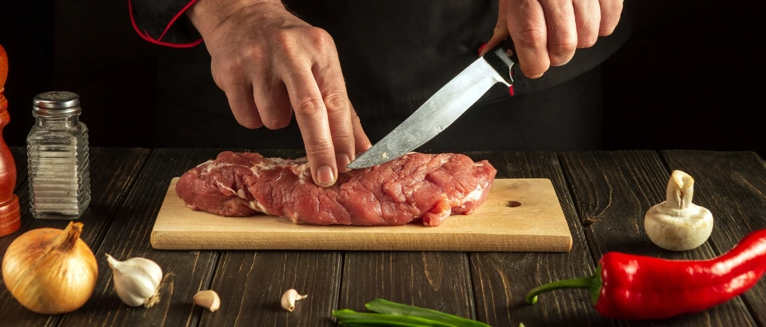 A chef cutting the meat