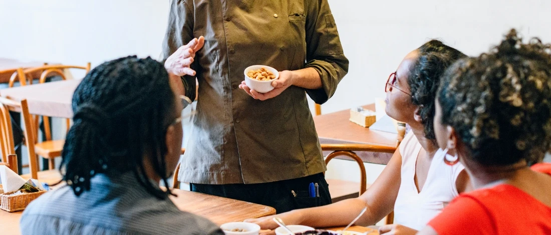 The chef is talking to the customers