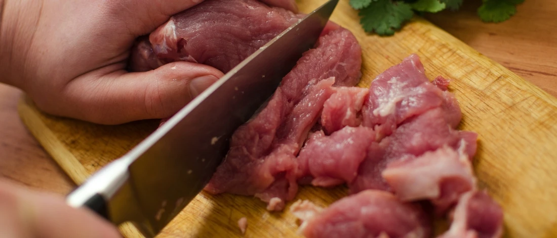 A person cutting the fresh meat