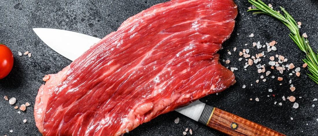 A slice of flank steak with a knife