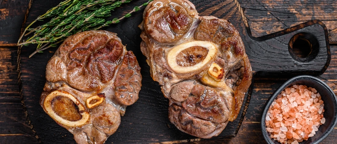 A cooked beef shank with salt on the side.