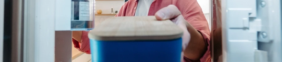 A person placing the container in the fridge