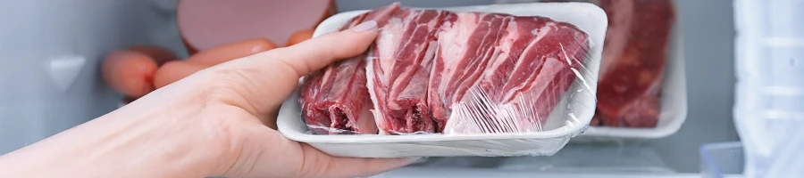 A person storing the meat in the fridge