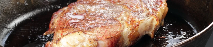 A steak cooking on a pan