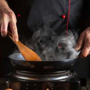 A man cooking a steak 
sauce