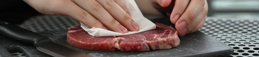 A person drying the meat