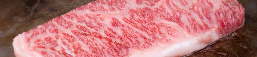 A juicy piece of steak cooking on a pan