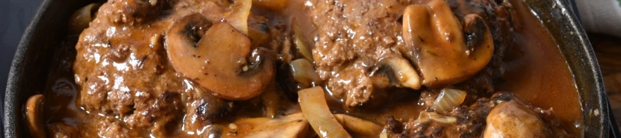 A top view of beef patties with sauce